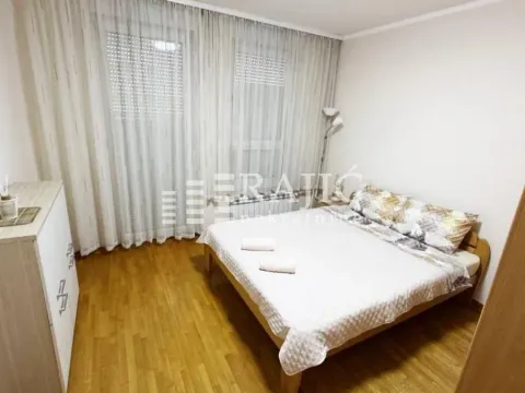 Bedroom with a double bed, wooden flooring, and a large window with curtains. - image 7