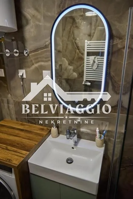 Modern bathroom with a washbasin and illuminated mirror.