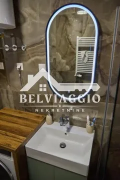 Modern bathroom with a washbasin and illuminated mirror. - image 18