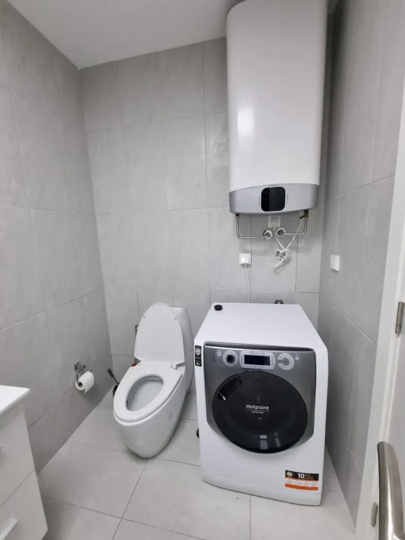 Kupatilo opremljeno toaletom, veš mašinom i bojlerom.