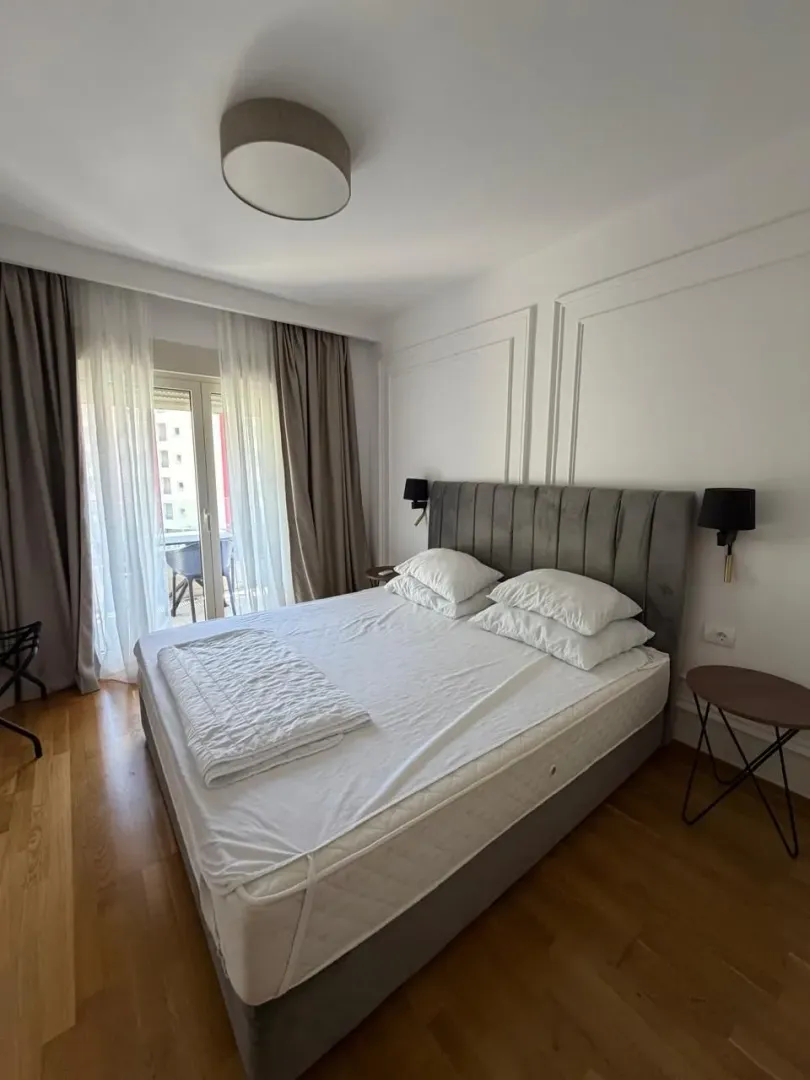Svijetla spavaća soba sa velikim krevetom i izlazom na terasu.