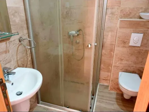 Manje kupatilo sa tuš kabinom, umivaonikom i toalet šoljom u bež tonovima. - image 4