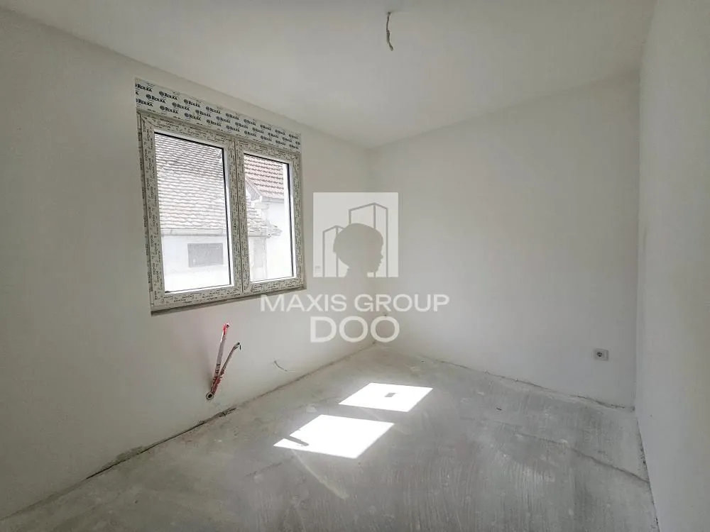 Empty unfinished room with a window in a building under construction.