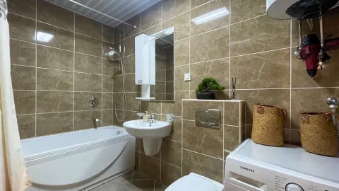 Kupatilo opremljeno kadom, umivaonikom, WC šoljom i veš mašinom. - image 10