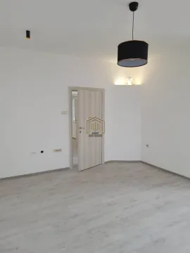 Empty room with light laminate flooring, white walls, and a wooden door. - image 9