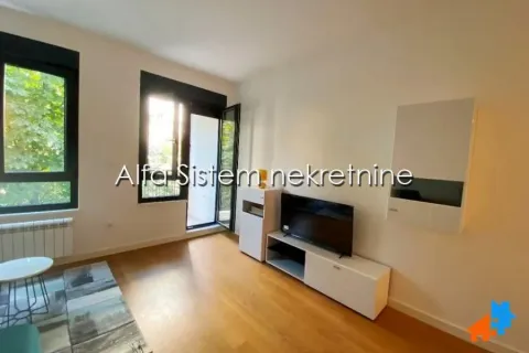 Living room with a television, wooden flooring, and access to the terrace. - image 2