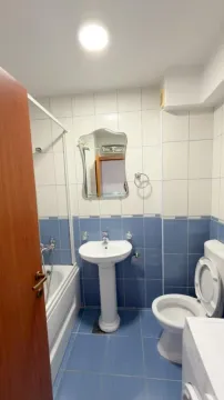Kupatilo opremljeno umivaonikom, wc šoljom, kadom i ogledalom. - image 9