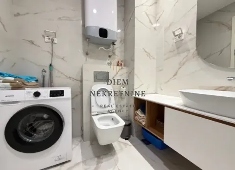 Modernly equipped bathroom with a washing machine and marble tiles. - image 9