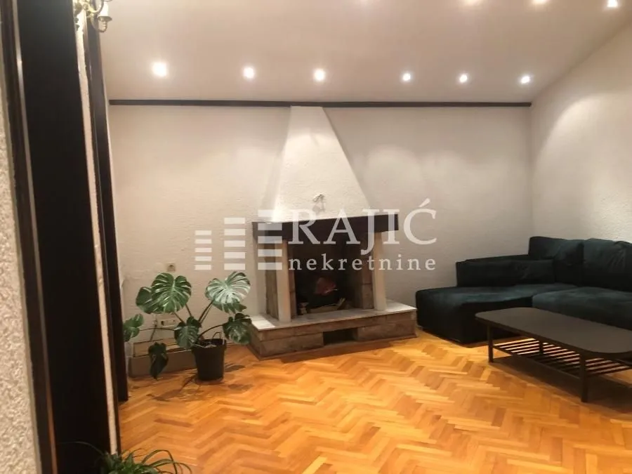 Living room with a fireplace and parquet flooring.