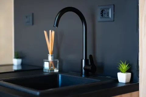 Moderna crna sudopera sa slavinom na tamnoj radnoj površini. - image 17