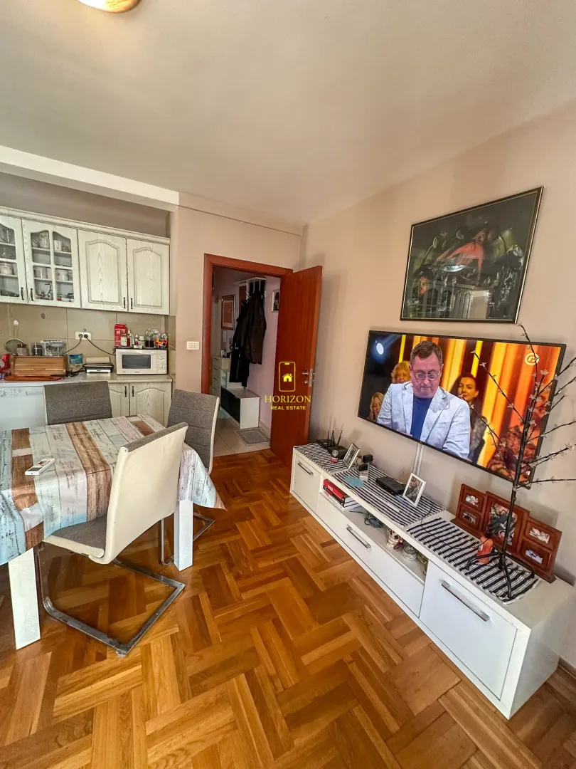 Dnevni boravak sa trpezarijom i kuhinjom u pozadini.