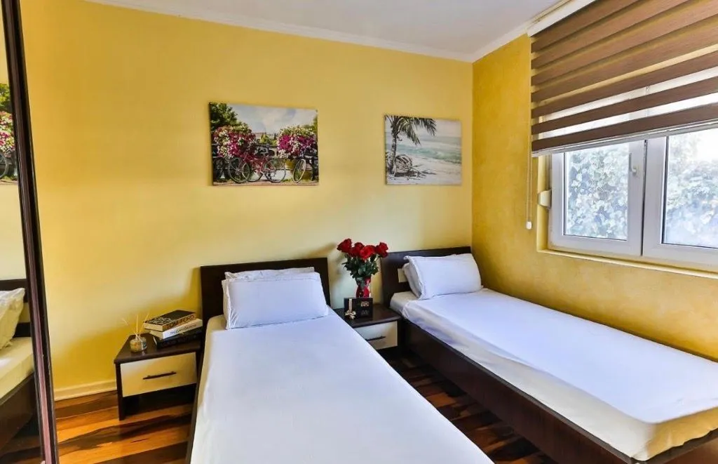 Bedroom with two single beds and yellow walls.