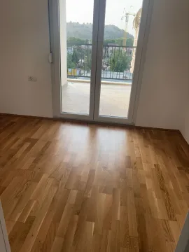Prazna soba sa drvenim parketom i izlazom na terasu. - image 6