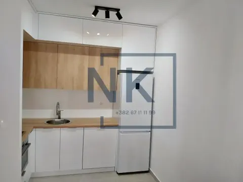 Compact white kitchen with wooden elements and a refrigerator. - image 5
