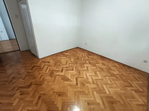 Empty room with white walls and wooden parquet flooring. - image 3