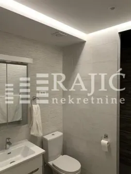 Modern bathroom with a sink, toilet, and mirror. - image 10