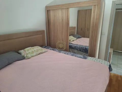 Furnished bedroom with a double bed and a wooden wardrobe with a mirror. - image 6