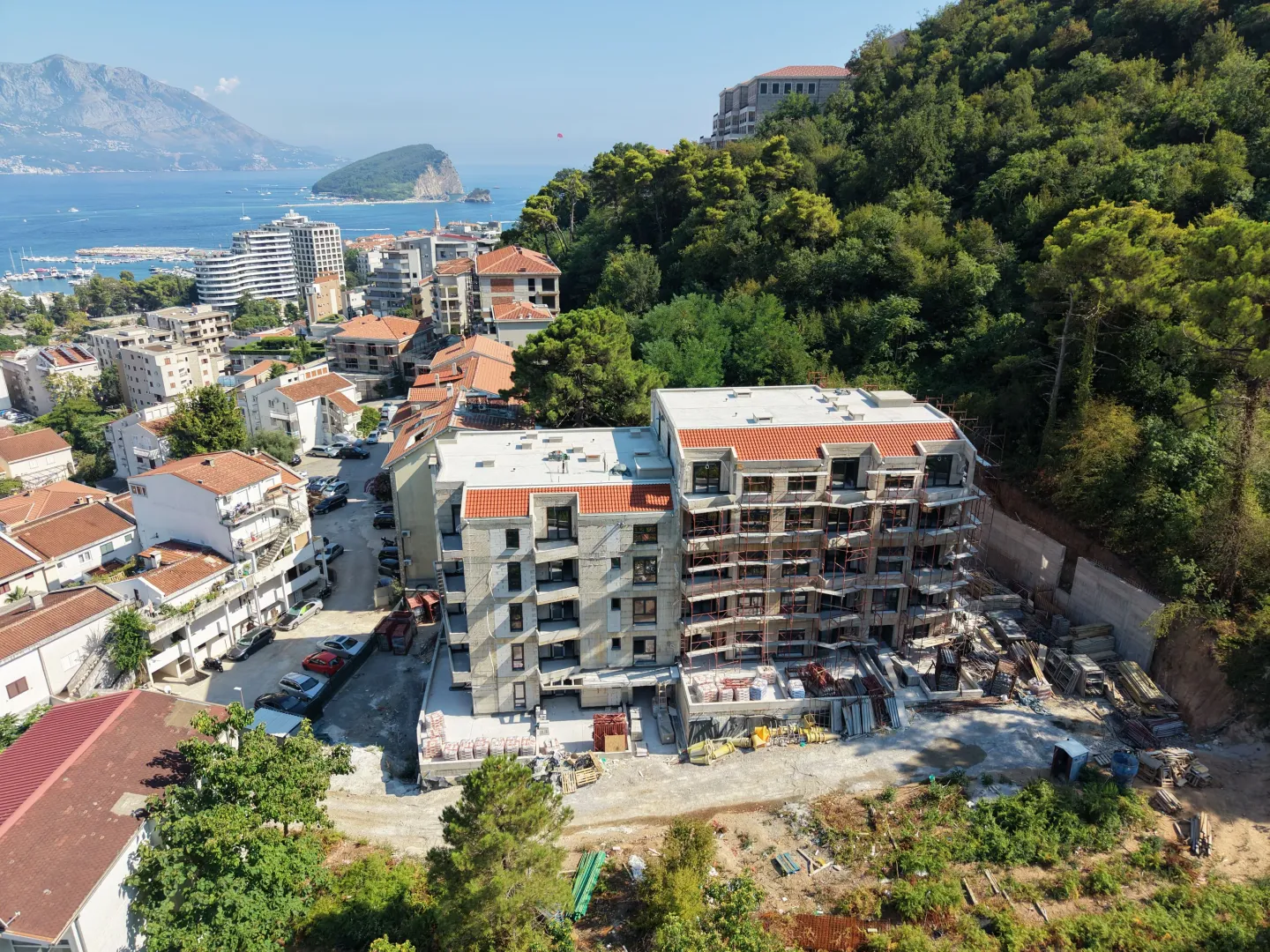 Pogled iz vazduha na stambeni objekat u izgradnji sa okolinom i pogledom na more.