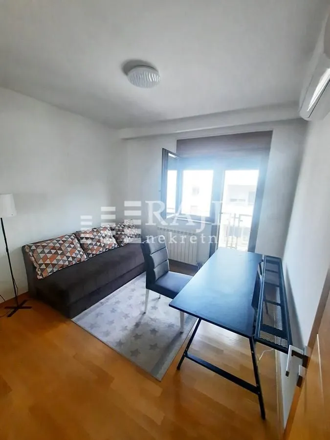 Small living room with a sofa, desk, and access to the terrace.