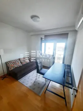 Small living room with a sofa, desk, and access to the terrace. - image 5