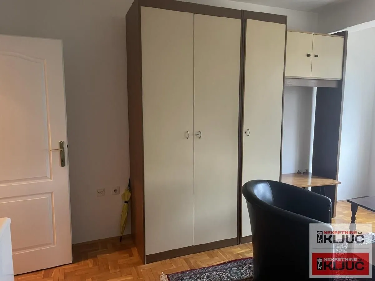 Spavaća soba sa velikim garderoberom i radnim stolom.