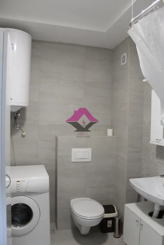 Bathroom equipped with sanitary fixtures, a washbasin, a washing machine, and a water heater.