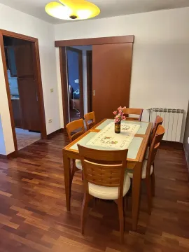 Dining area with a wooden table and chairs in an apartment. - image 5
