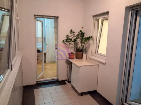 Zastakljeni balkon sa pločicama, komodom i saksijama sa cvijećem. - image 12
