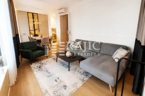 Living room with a sofa, coffee table and dining area in the background. - image 2