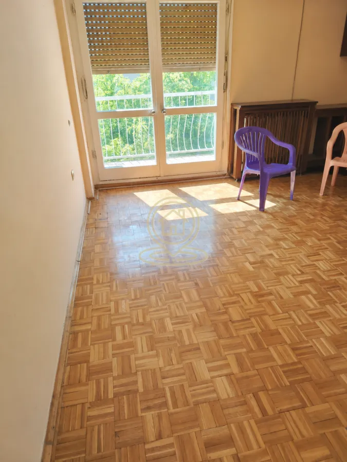 Prazna soba sa parketom i izlazom na terasu.