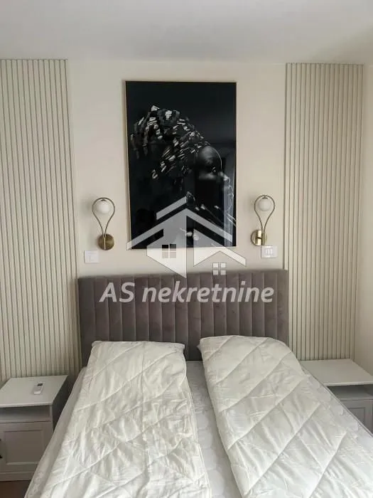 Modern bedroom with a double bed, headboard, and decorative wall panels.