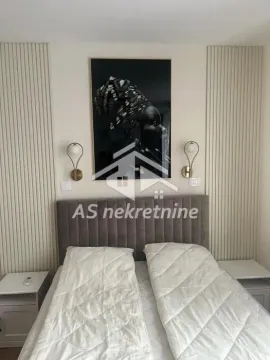 Modern bedroom with a double bed, headboard, and decorative wall panels. - image 17