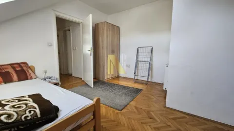 Manja spavaća soba sa krevetom, drvenim ormarom i parketom na podu. - image 14