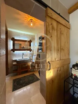 Kupatilo sa drvenim kliznim vratima, umivaonikom i rustičnim detaljima. - image 39