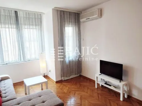 Living room with sofa, TV, and air conditioning. - image 2