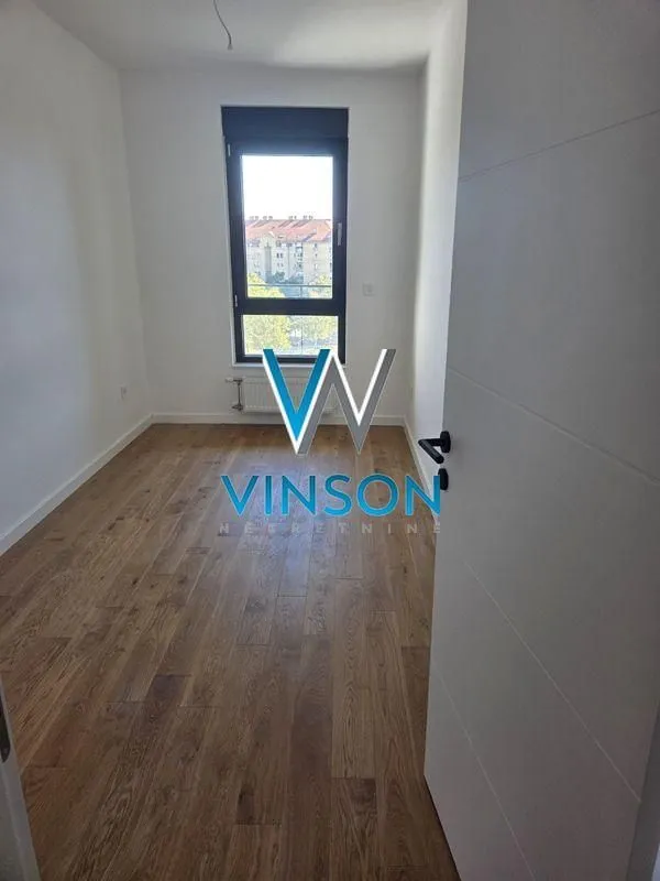 Empty room with wooden flooring and a window.