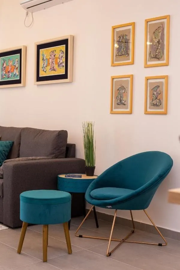 Living room with a comfortable sofa, blue armchair, and pictures on the wall.