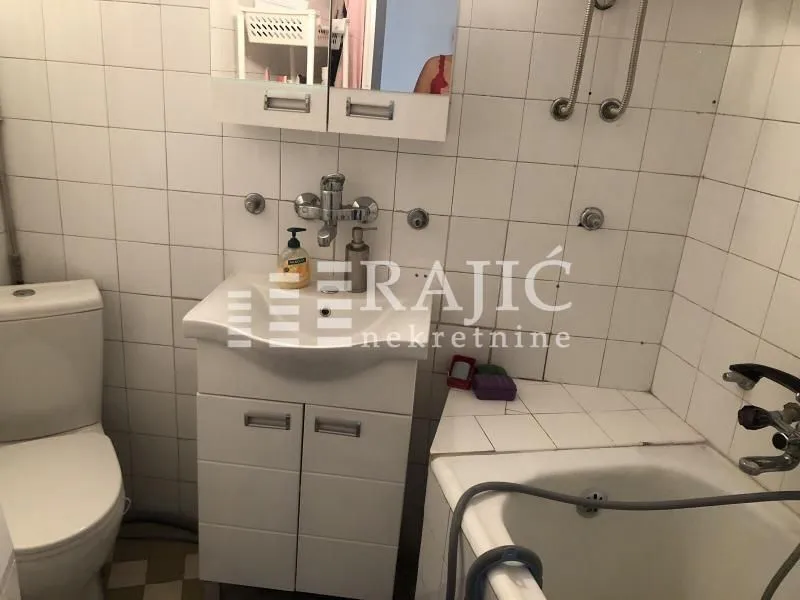 Smaller bathroom with a sink, toilet, and bathtub.