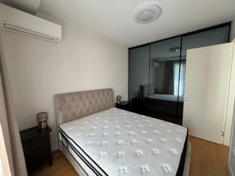 Bright bedroom with a double bed and built-in wardrobe. - image 7