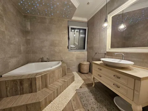 Modern bathroom with a corner bathtub and a washbasin. - image 9