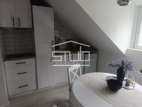Small kitchen with white units and a dining table in the attic. - image 10