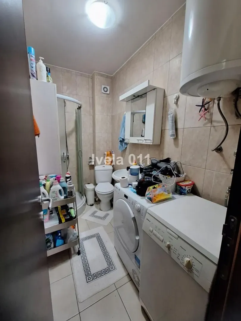 Kupatilo opremljeno sanitarijama, tuš kabinom i veš mašinom.