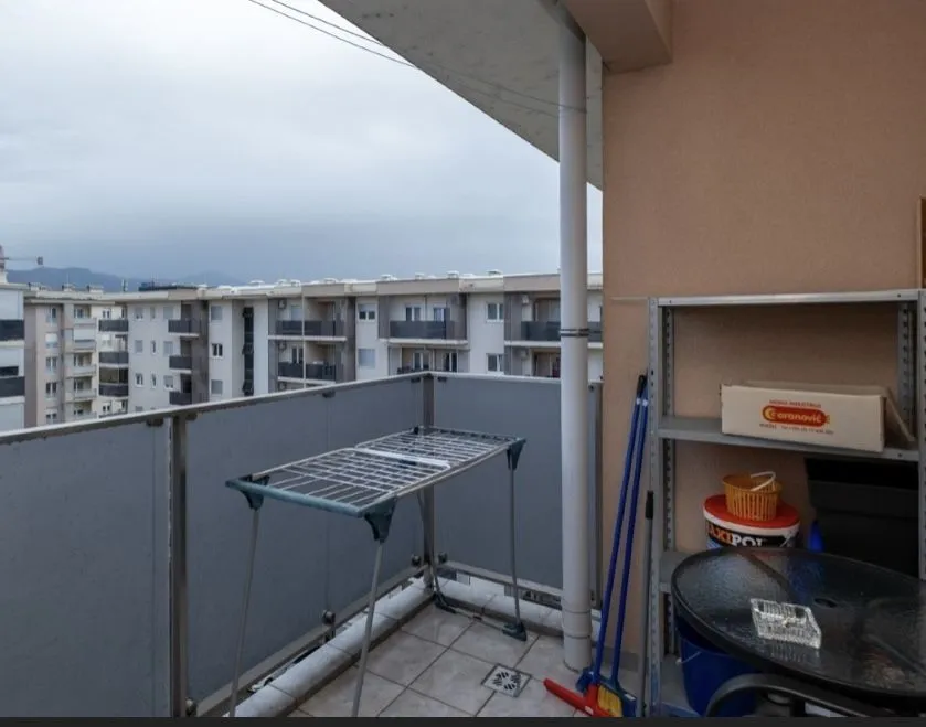 Balkon sa sušilicom za veš i pogledom na susjedne zgrade.