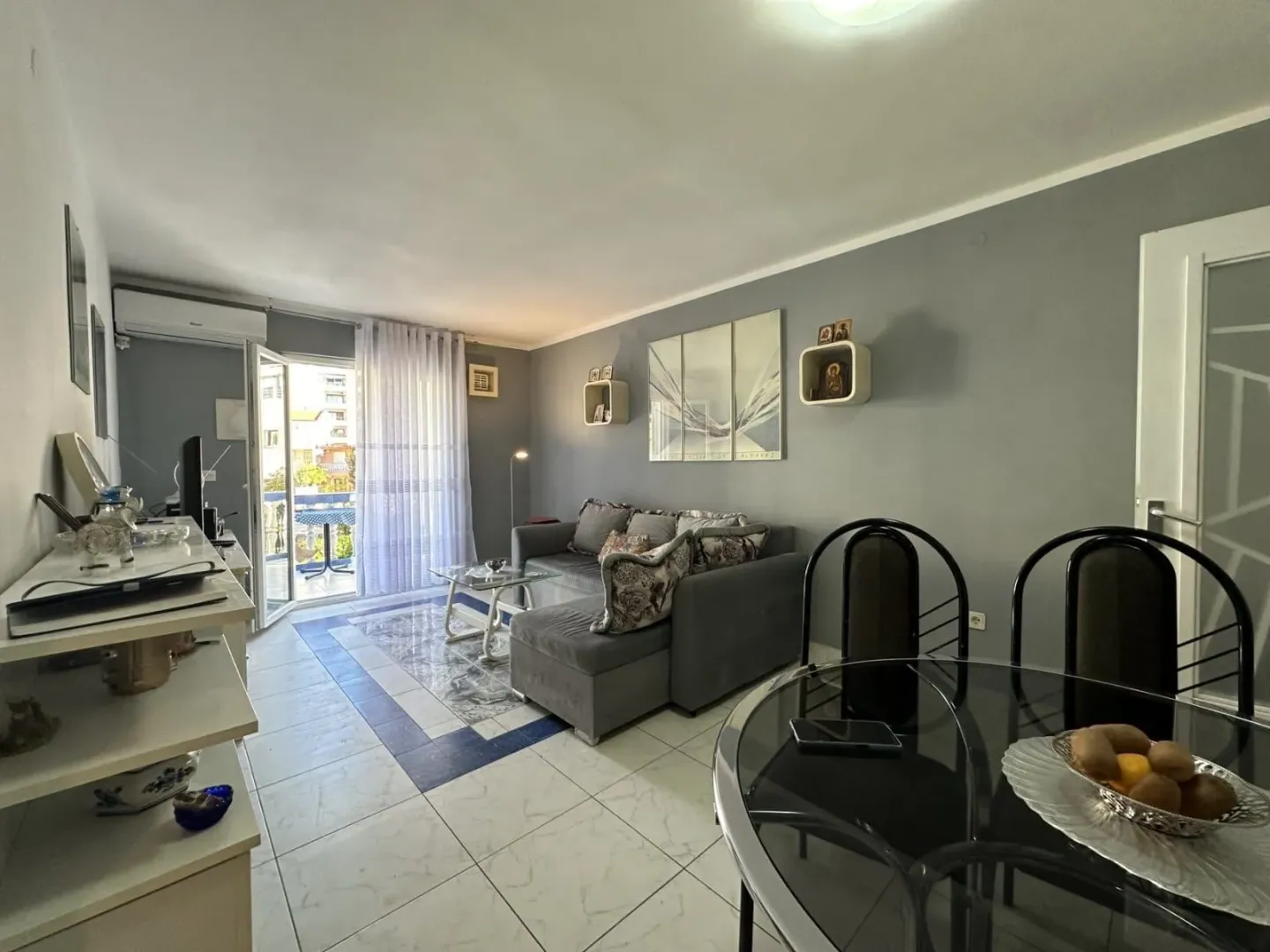 Living room with a sofa set, dining table and access to the terrace.