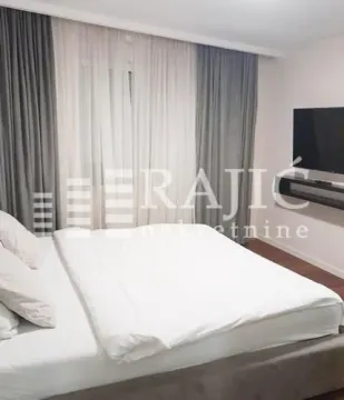 A furnished bedroom with a double bed, TV, and curtains. - image 3