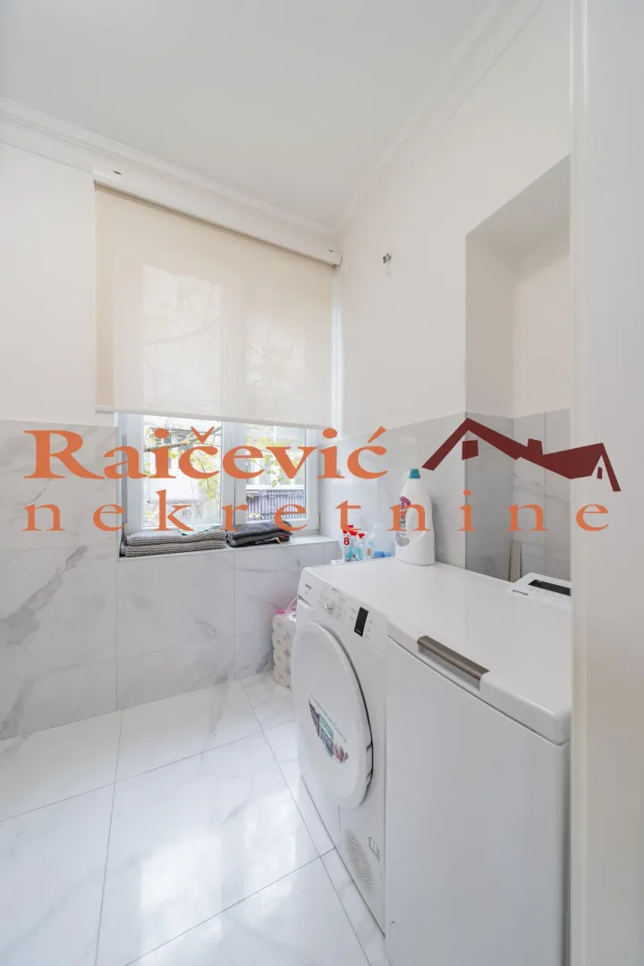 Bathroom with a washing machine and a window.