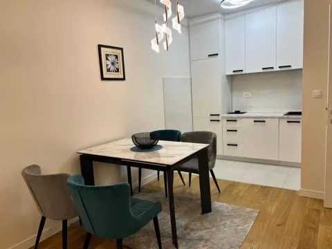 Modern kitchen with dining area and white cabinets. - image 9