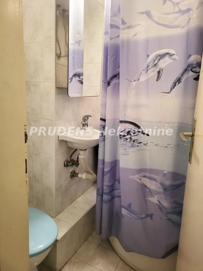 Smaller bathroom with a shower cabin, washbasin, and mirror.