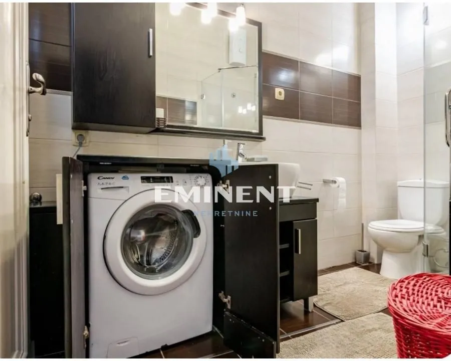 Bathroom equipped with sanitary ware, a shower cabin, and a washing machine.