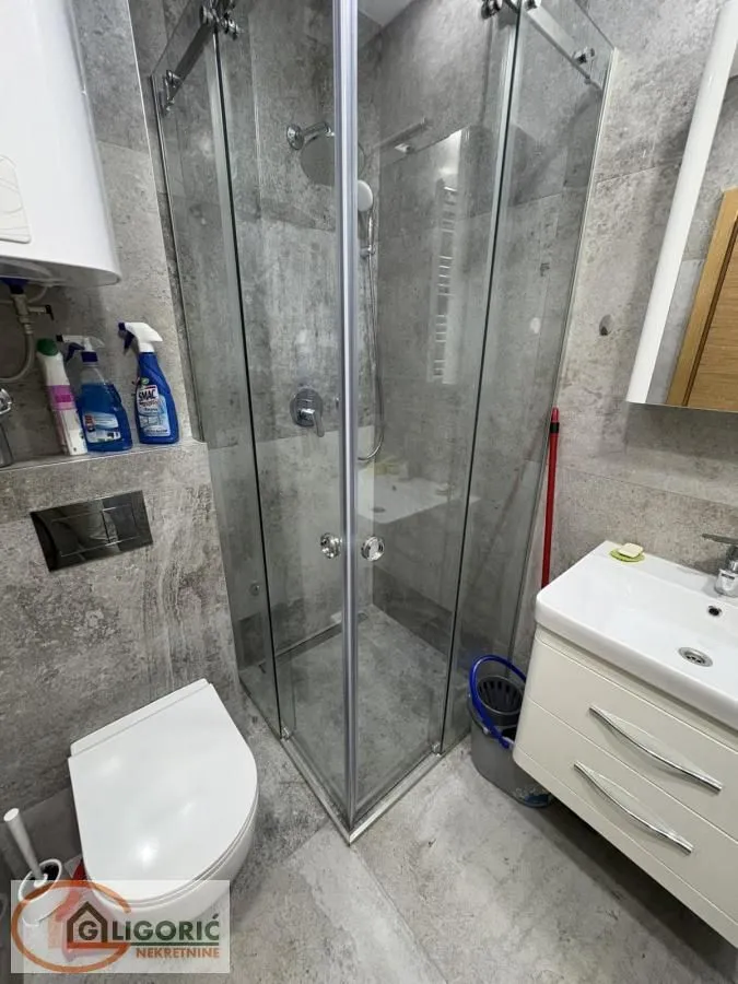 Manje kupatilo sa tuš kabinom, umivaonikom i wc šoljom.